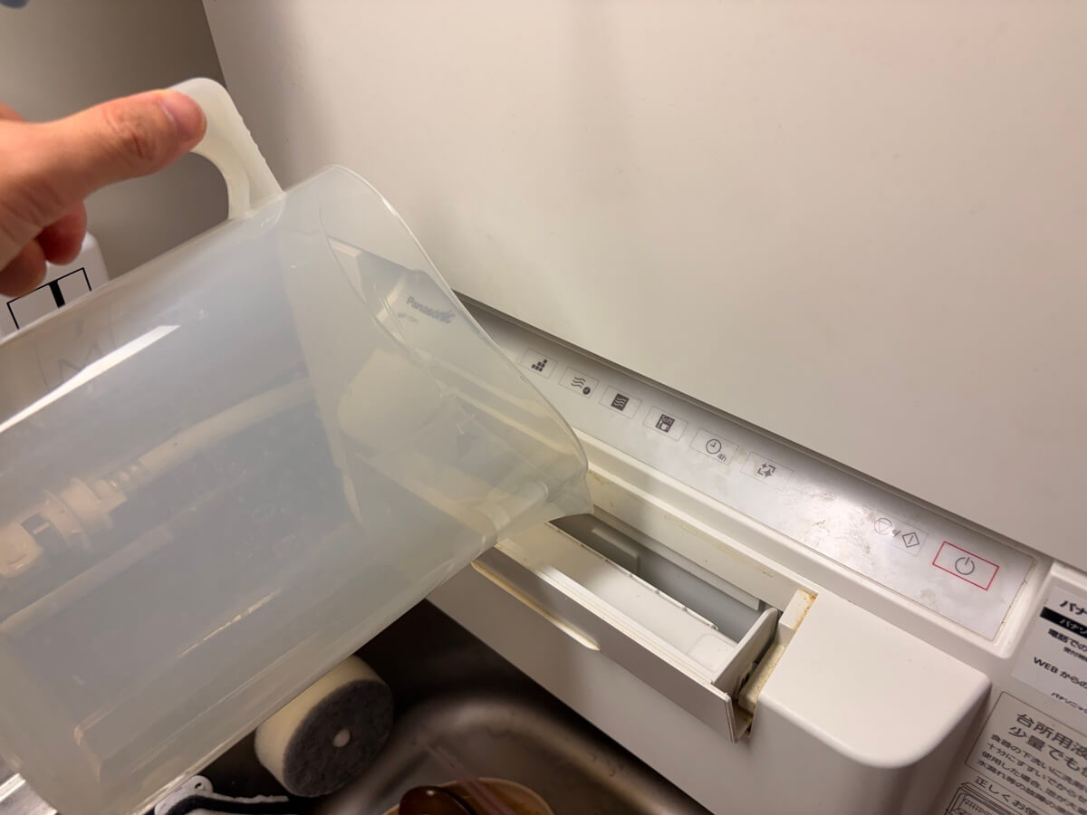 NP-TSP1の給水口へ付属の給水カップで水を入れているところ