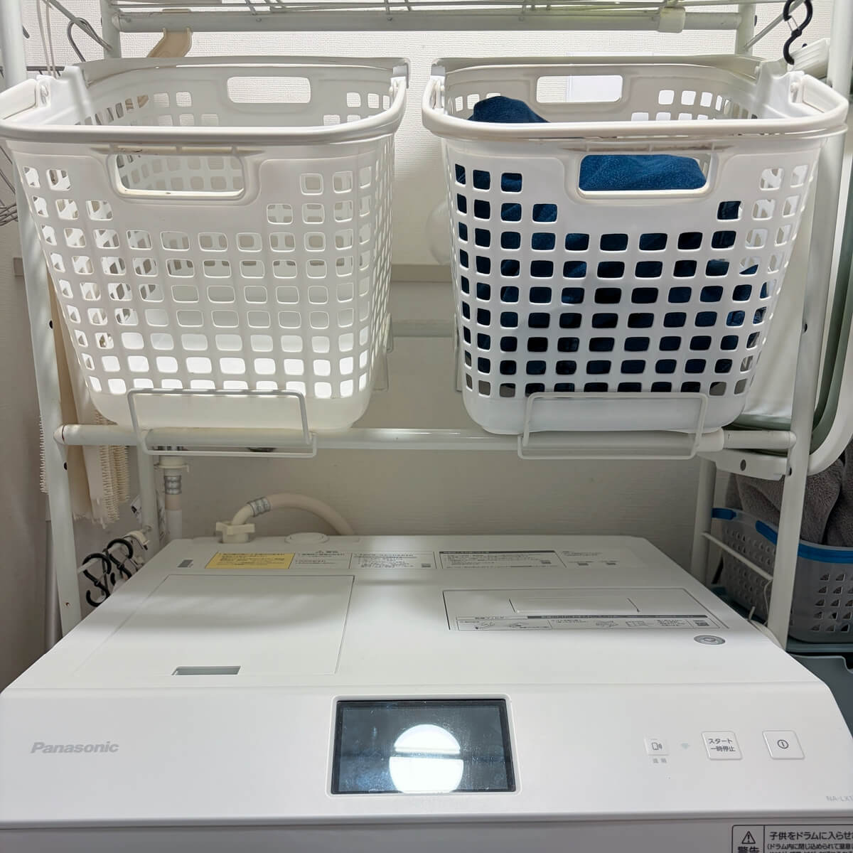ドラム式洗濯機の上に洗濯用と乾燥用の2つのカゴを置いた様子